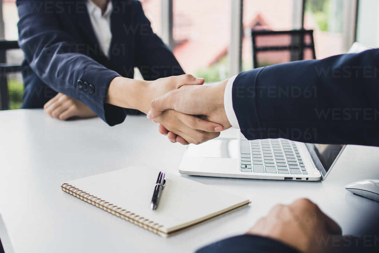 Biznesmen w krawacie przedstawia się koleżance z pracy gestem otwartej dłoni