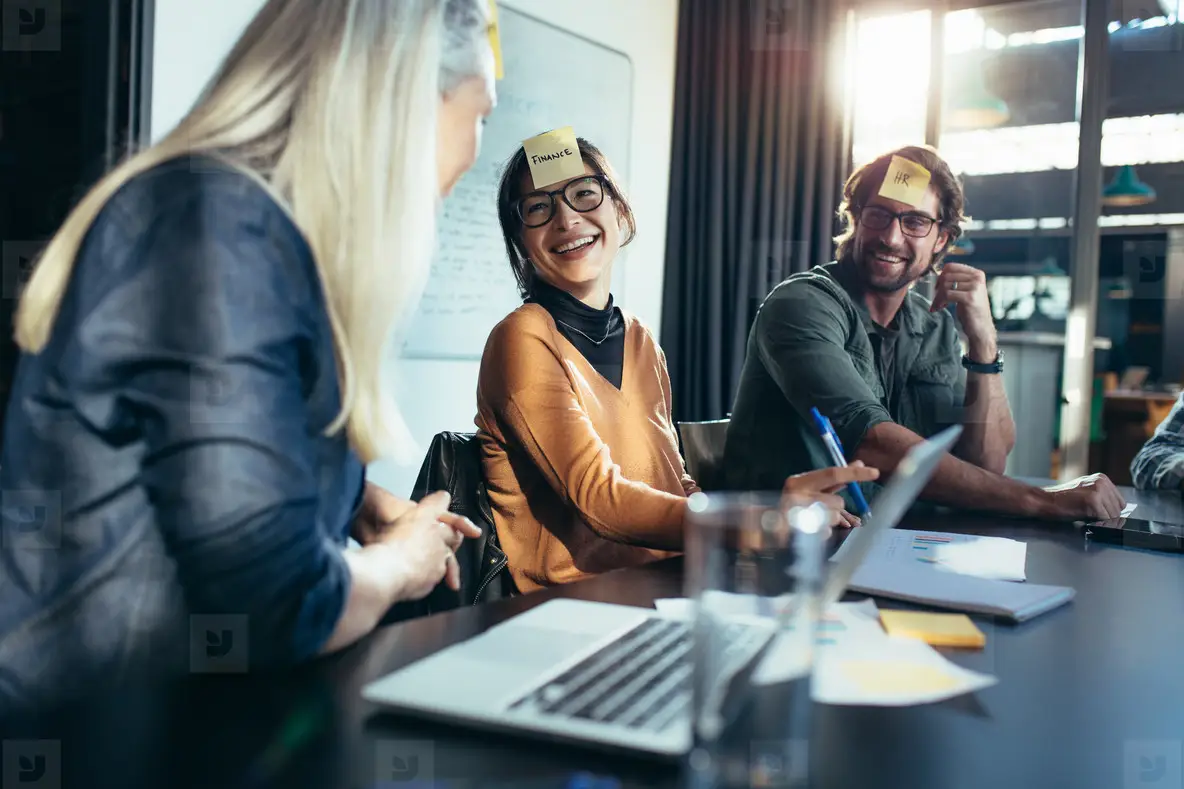 Zegar piaskowy odlicza czas sesji burzy mózgów z napiętą grupą wokół stołu