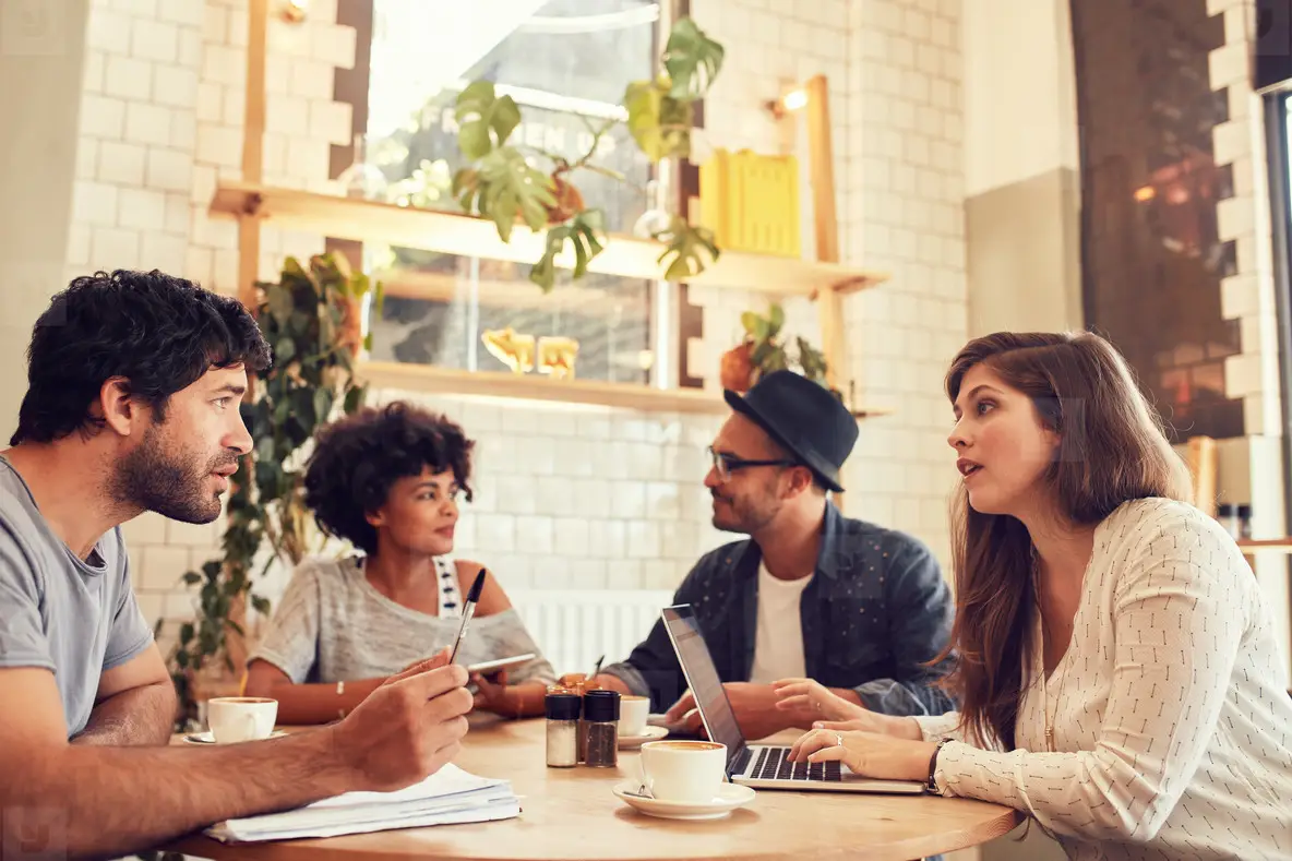 Filiżanki kawy na tarasie kawiarni z roślinami i miejskim otoczeniem