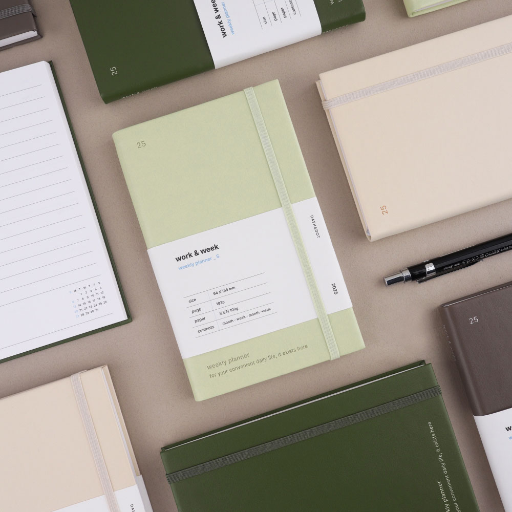 młoda kobieta przy biurku z plannerem laptopem i kawą planuje tydzień pracy