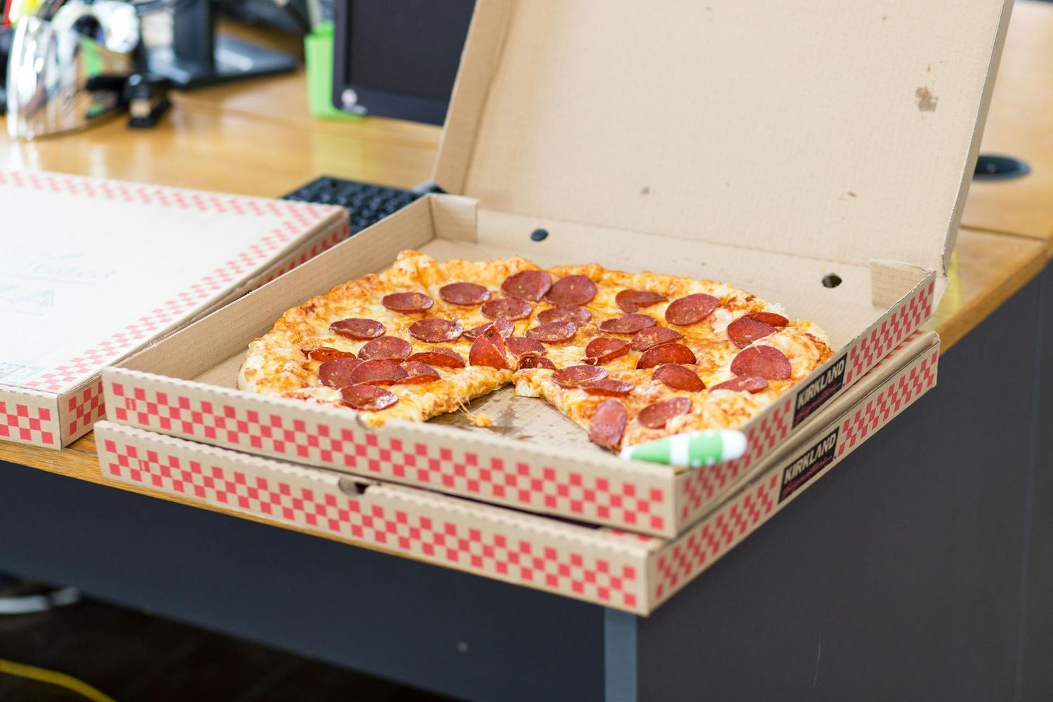 kobieta w garniturze podnosi kawałek pizzy z serem ciągnącym się
