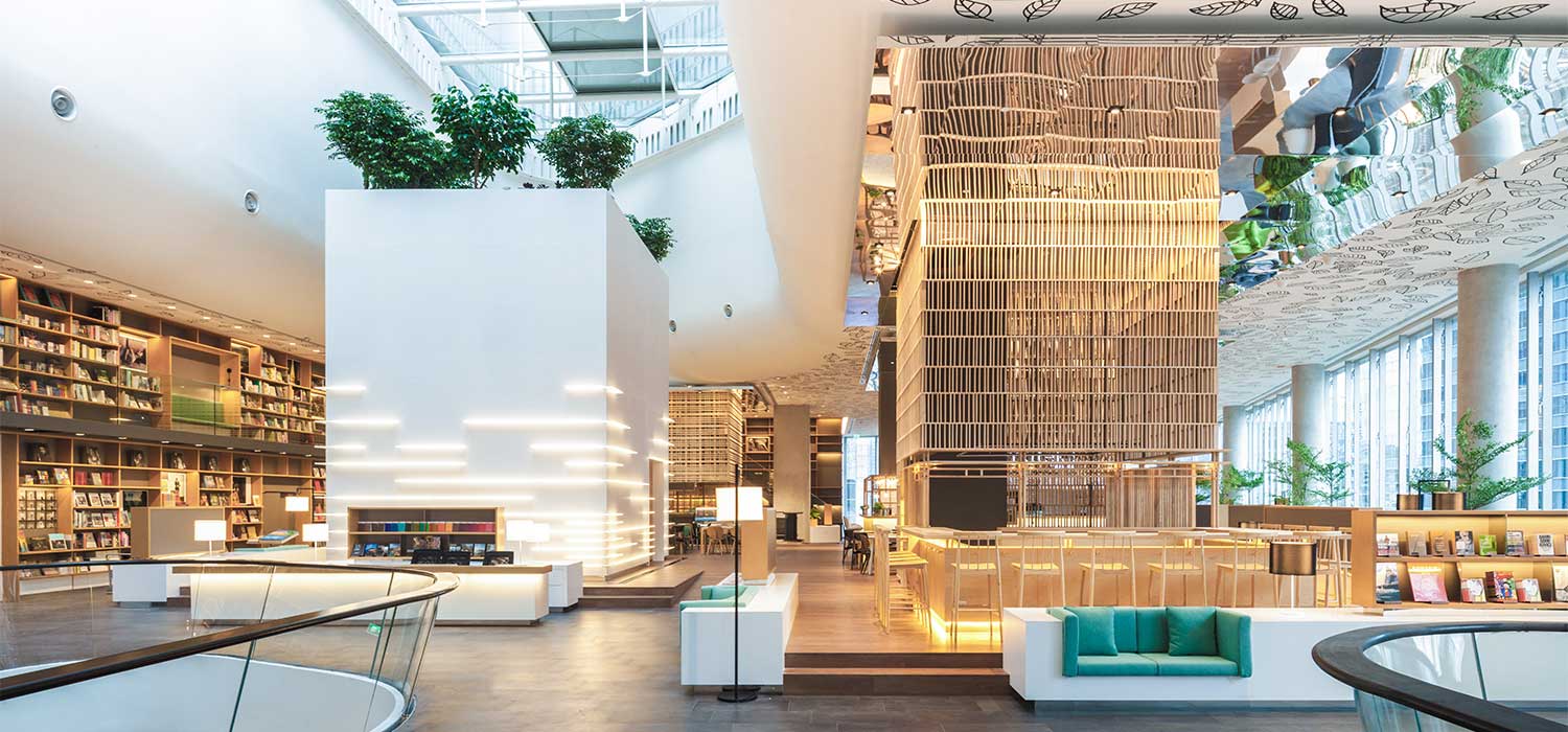 przestrzeń open space biura coworking open space z laptopami pracującymi osobami roślinami i ergonomicznymi krzesłami