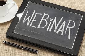 osoba prowadząca webinar z uśmiechem na ekranie laptopa